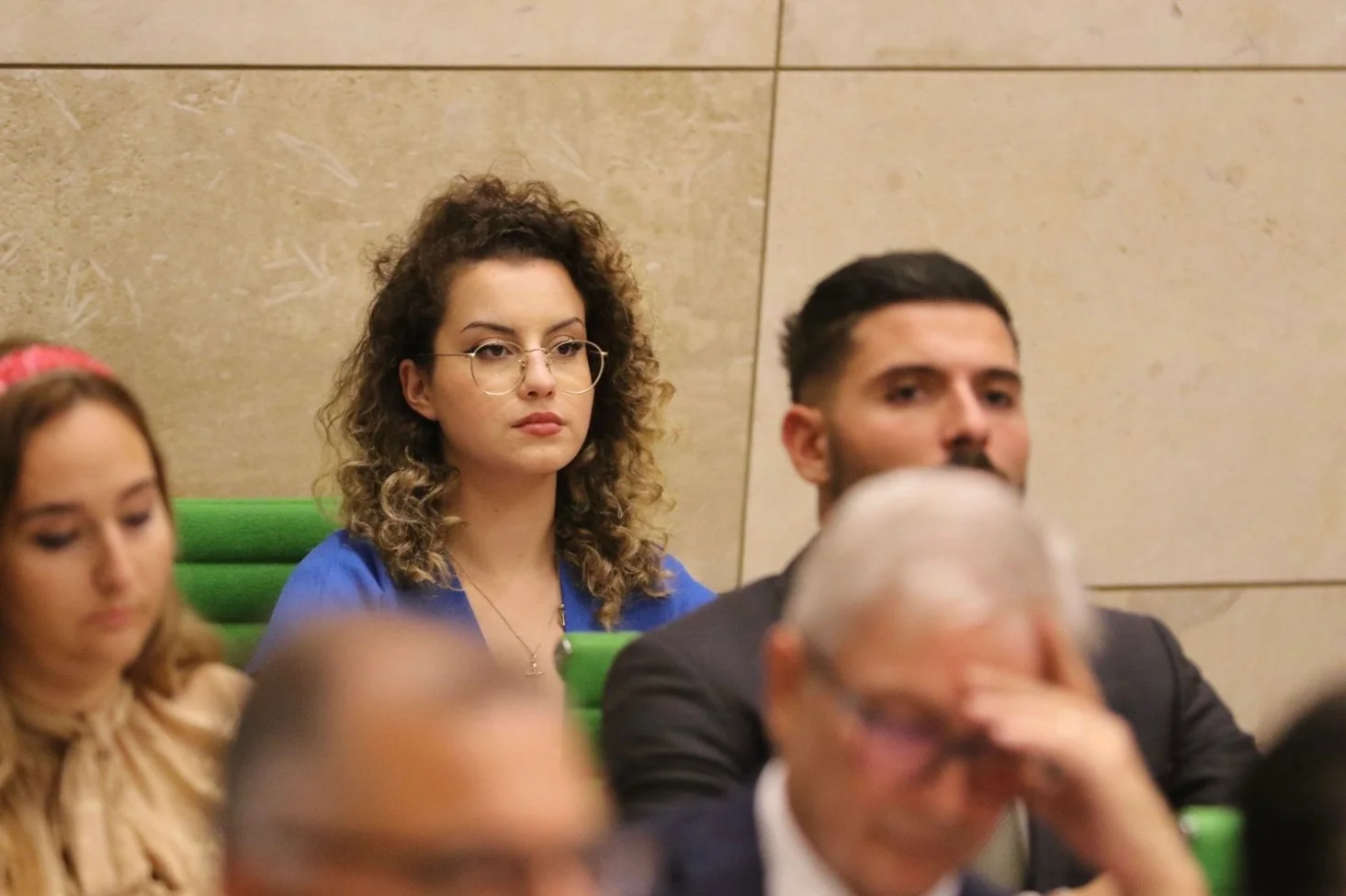 Eve Borg Bonello at a formal press conference, seated at table with microphone